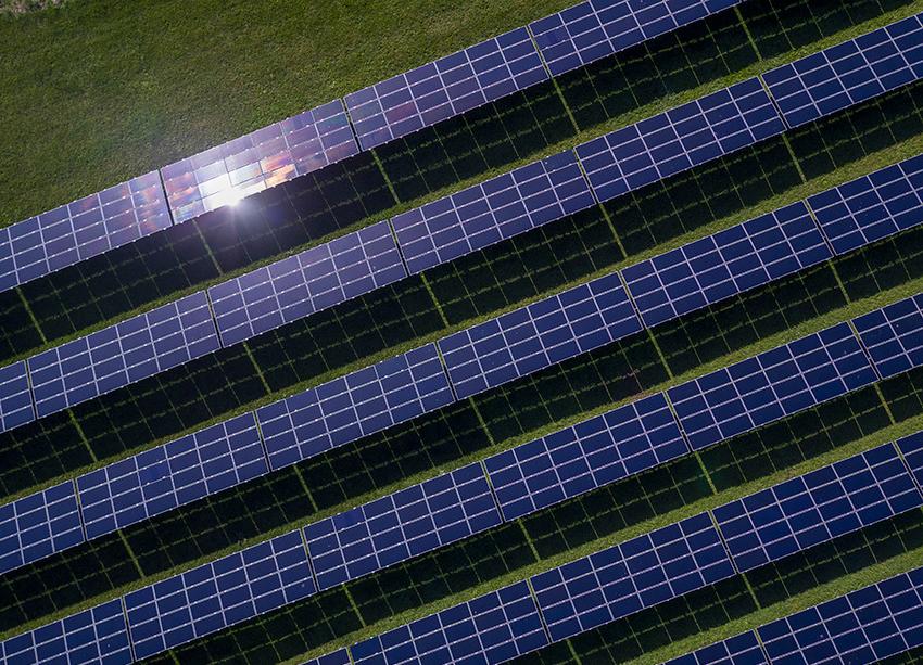 草地上一排排的太阳能电池板.